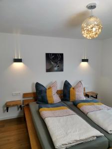 a living room with two beds and a chandelier at Moderne Ferienwohnung Gartenblick in Amtzell