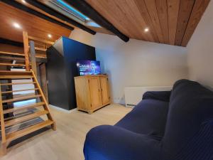 a living room with a blue couch and a tv at Gite Familiale La Classe in Modave