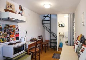 a living room with a table with a microwave and a staircase at tiny house EFROSSINI in Krásion