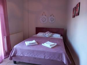 a bedroom with a purple bed with two towels on it at Selene's House in Skala Kallirachis