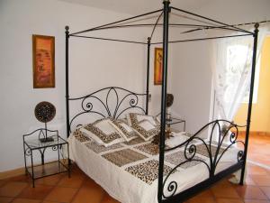 サリ・ソランザラにあるLa Villa Case Marineのベッドルーム(黒い天蓋付きベッド1台、テーブル付)