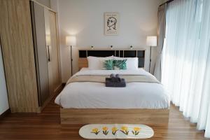 een slaapkamer met een groot bed met witte lakens bij My happy place in CNX in Chiang Mai