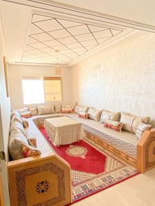 ein Wohnzimmer mit einem Sofa und einem Tisch in der Unterkunft Apartment Familiale Al-Hoceima, Vue sur mer 