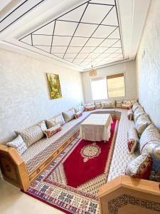 ein Wohnzimmer mit einem Sofa und einem Tisch in der Unterkunft Apartment Familiale Al-Hoceima, Vue sur mer 
