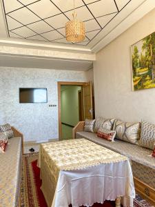 um quarto com uma cama, um sofá e uma televisão em Apartment Familiale Al-Hoceima, Vue sur mer 