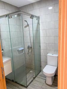 uma casa de banho com uma cabina de duche em vidro e um WC. em Apartment Familiale Al-Hoceima, Vue sur mer 
