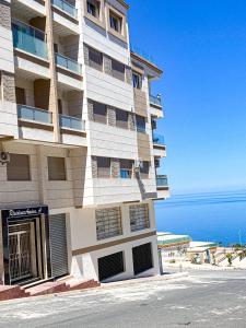 um edifício alto com o oceano ao fundo em Apartment Familiale Al-Hoceima, Vue sur mer 