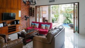 a living room with a couch and a table at The Lavana Jasmine Villa in Senggigi