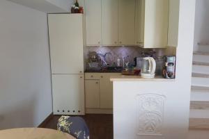 a kitchen with white cabinets and a counter top at Kołatek Mazury Apartament z widokiem in Olsztynek