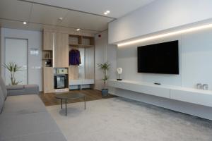 a living room with a flat screen tv on a wall at Premier Hotel Miskolc in Miskolc