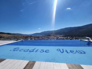 a blue swimming pool with the words abuse water on it at Вилно селище PARADISE VIEW in Sarnitsa