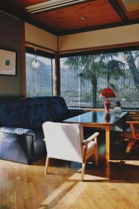 a living room with a table and a couch at 湯布院我楽珍民泊Yufuin Garakuchin in Yufuin