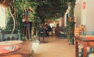 un restaurante con un montón de plantas en las paredes en Hostal Esfigueral en Playa es Figueral