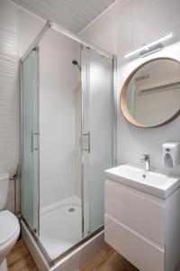 a bathroom with a shower and a sink and a mirror at Lech Resort & Spa in Łeba