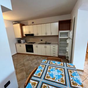 cocina con mesa, sillas y encimera en Trentino Apartments - Casa ai Fiori, en Folgaria