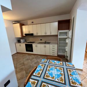 una cucina con tavolo, sedie e piano di lavoro di Trentino Apartments - Casa ai Fiori a Folgaria Altre 5 foto