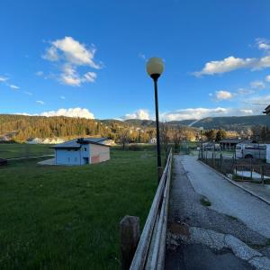 una luz de la calle junto a un campo con una valla en Trentino Apartments - Casa ai Fiori, en Folgaria