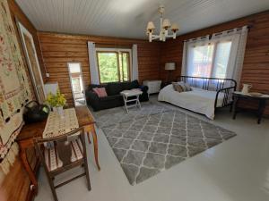 a living room with a bed and a couch at VillaTorppa in Jämsä