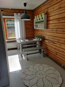 a room with a bench and a table and a window at VillaTorppa in Jämsä