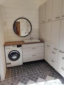 lavadero con lavadora y espejo en VillaTorppa en Jämsä