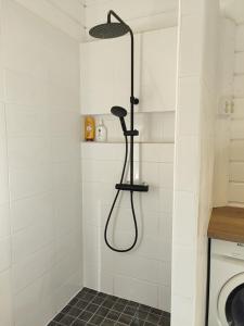 een douche met een douchekop in de badkamer bij VillaTorppa in Jämsä