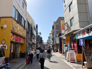 um grupo de pessoas andando por uma rua da cidade em Belle harmonie 102 em Tóquio