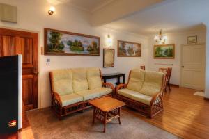 a living room with two chairs and a table at PLAY at Arabella Tudor House in Tanah Rata