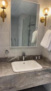 a bathroom with a white sink and a mirror at Damac Al Jawharah Tower Apartments in Jeddah