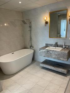 a bathroom with a large tub and a sink at Damac Al Jawharah Tower Apartments in Jeddah