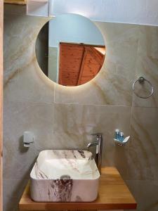 een badkamer met een wastafel en een spiegel bij Porta7 Hotel in Gjirokastër