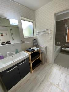 IchinomiyaにあるPleasure Point Ichinomiyaの洗面台、鏡、浴槽のあるバスルーム