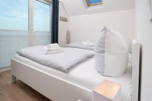 オルペニッツにあるOstseetörnの白いベッドルーム(ベッド2台、窓付)