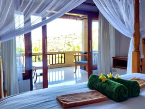 艾湄灣的住宿－Sama Sama Amed，一间卧室设有一张床和一个阳台