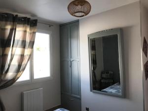 pokój z lustrem i oknem i elementem dekoracyjnym okna w obiekcie Appartement avec piscine - rez de jardin w mieście Pailhès +14 zdjęć
