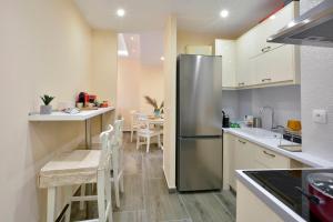 a kitchen with a stainless steel refrigerator and a table at Saroko House in Corfu
