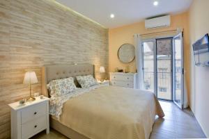 a bedroom with a bed and a brick wall at Saroko House in Corfu