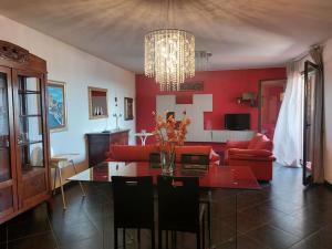 a living room with a dining table and red walls at Casa Cuore in Marsala