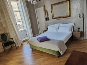 a bedroom with a large bed and a large window at Dimora Aretusa Luxury in Siracusa
