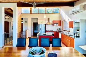 uma cozinha com armários vermelhos e cadeiras azuis em The Beautiful Grand Terrace (Seaview) em Mount Martha