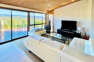 uma sala de estar com um sofá branco e uma grande janela em The Beautiful Grand Terrace (Seaview) em Mount Martha