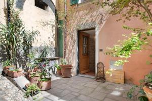 uma entrada para um edifício com vasos de plantas e uma porta em Casa di Gina em Levanto