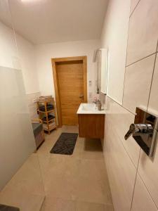 a bathroom with a sink and a wooden door at Landhaus Stadlmann in Thalgau