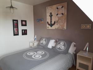 a bedroom with a bed with black and white pillows at Kermarco in Trégourez