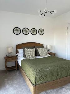 a bedroom with a bed with three clocks on the wall at Outstanding 4-Bedroom Town House By Valore Property Services in Milton Keynes