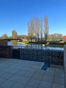 a stone wall next to a river with a bridge at Outstanding 4-Bedroom Town House By Valore Property Services in Milton Keynes