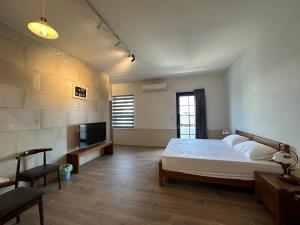 a bedroom with a bed and a television in it at 九屏文旅 JP guesthouse in Xiyu