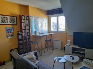 a living room with a couch and a tv and a table at Kermarco in Trégourez