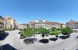 a courtyard with trees and buildings in a city at Hotel Infanta Isabel by Recordis Hotels in Segovia