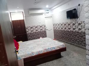 Habitación pequeña con cama y TV. en Sri Mahalakshmi Deluxe Lodging Arakonam en Arakkonam