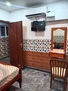 a room with a mirror and a table and a chair at Sri Mahalakshmi Deluxe Lodging Arakonam in Arakkonam